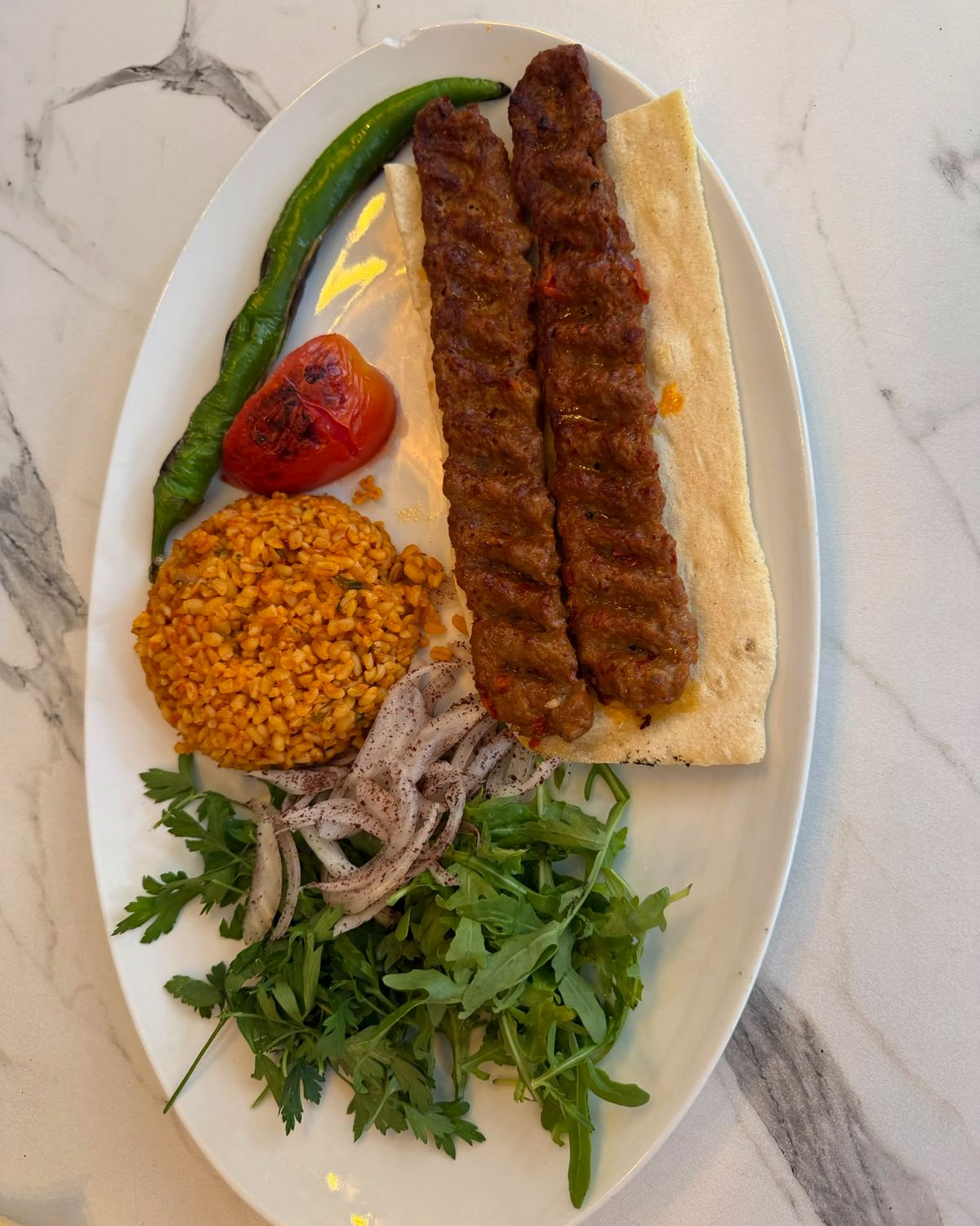 Adana kebap grillé servi avec boulgour, salade et lavash