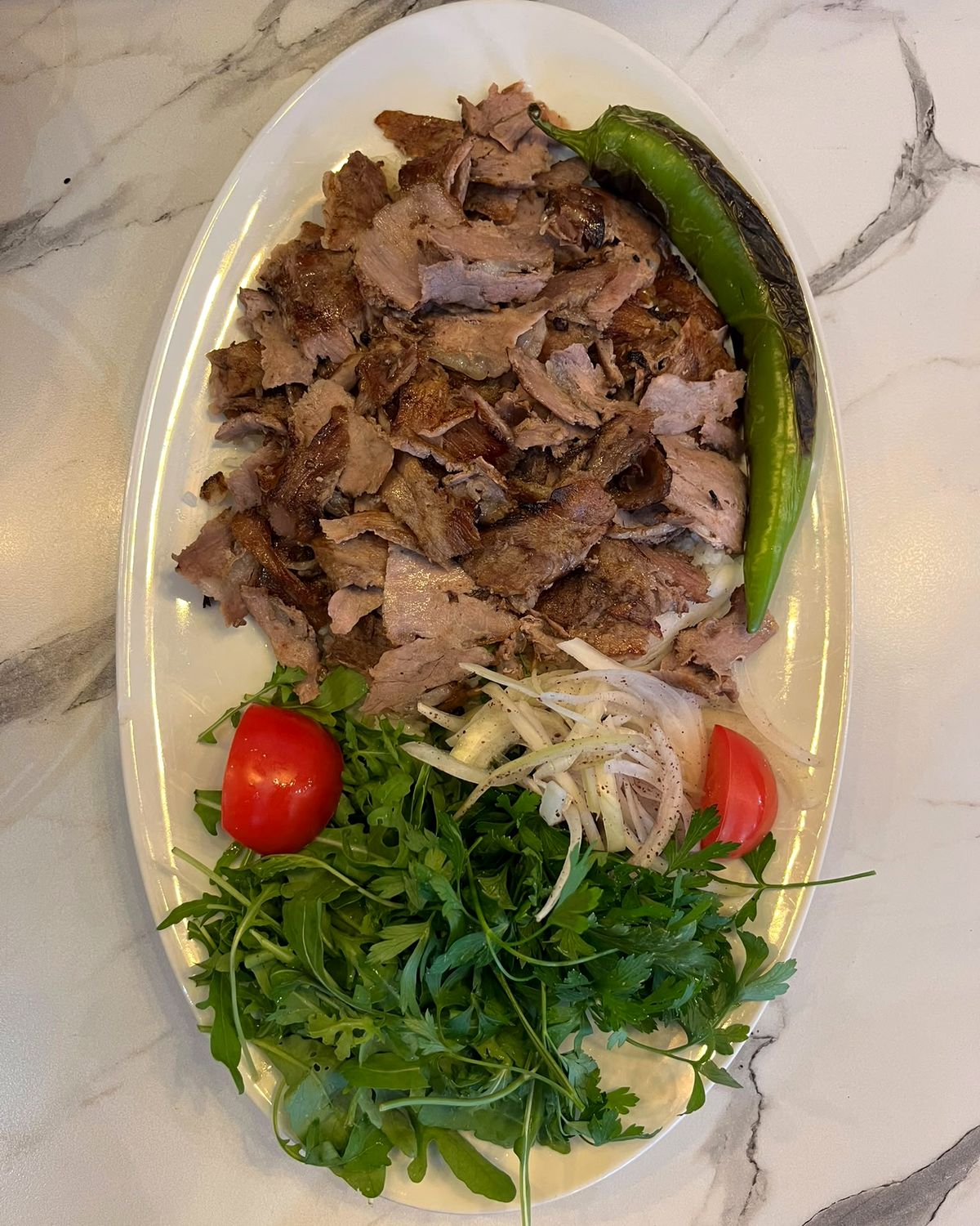 Assiette de döner avec roquette, oignons, tomates et piment grillé